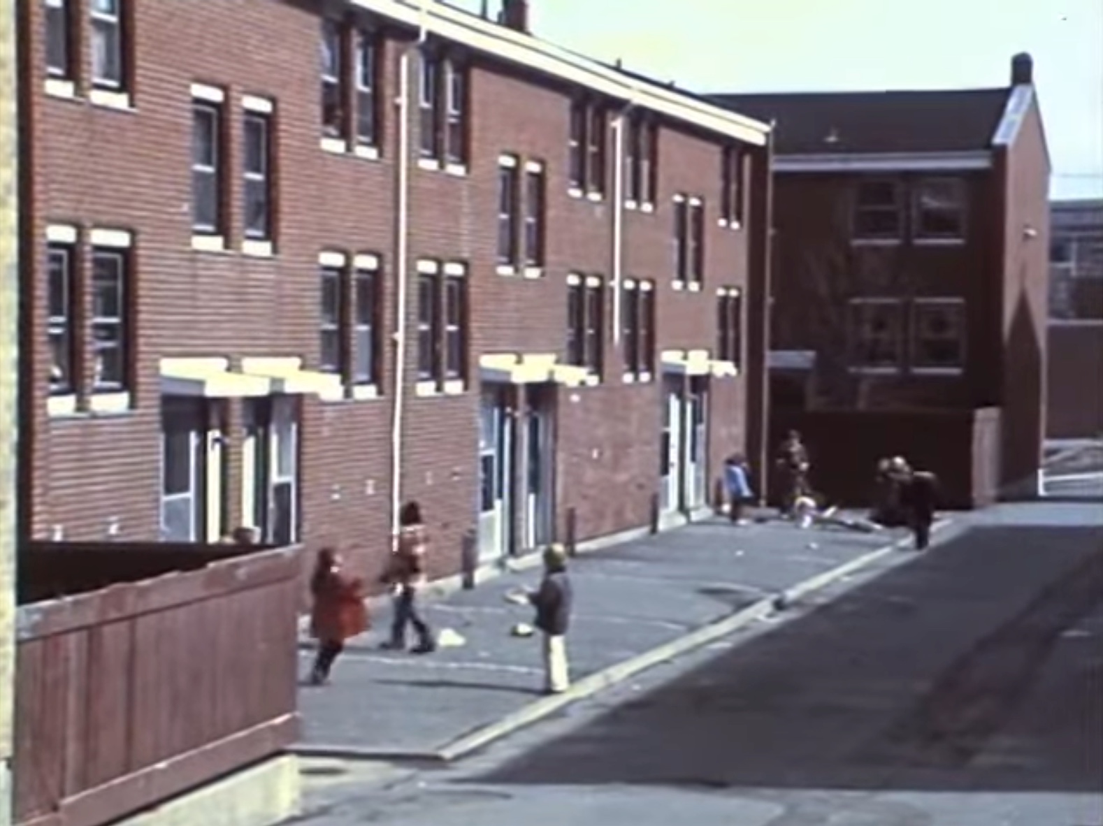 Children playing jump rope outside of a housing complex (Remember Africville, 00:26:25).